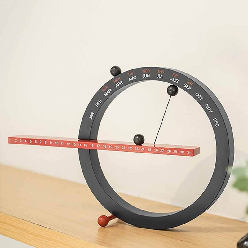 horloge calendrier perpetuel magnetique noir sur une table
